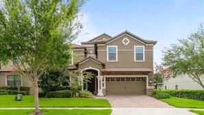 A two-story house with a garage, a front porch, and a well-maintained lawn.