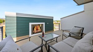 Una terraza en la azotea con una chimenea, asientos y vistas del entorno.