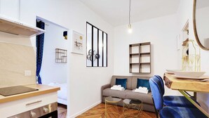 Un salon moderne comprenant un canapé, une table basse et un coin repas avec une table et des chaises.