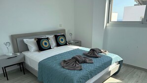 A modern bedroom with a bed, two bedside tables, a nightstand, and a window.