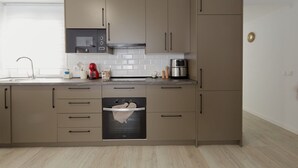 A modern kitchen with built-in appliances, a microwave, oven, and a coffee maker.