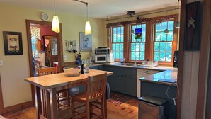 Une cuisine dotée de plans de travail en bois, d’un îlot central et d’un coin repas.
