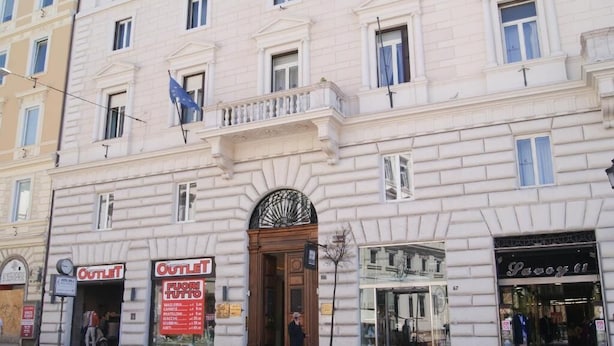 A building with multiple storefronts, including an 'Outlet' sign and a 'Pavoni' store. - Esposizione Luxury Rome (Rome)