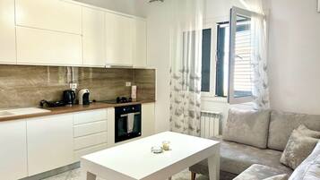 Appartement, 2 chambres, balcon, vue colline | Coin séjour | Télévision à écran plat de 32 pouces avec chaßnes par cùble