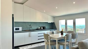 Departamento, 1 cama Queen size y sofá cama, balcón, vista a la colina | Cocina privada | Refrigerador con congelador, microondas, horno y parrilla de estufa