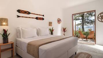 Ein Schlafzimmer mit Bett, Nachttischen und Blick ins Freie.