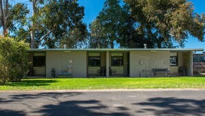 A single-story building with a flat roof, large windows, and a small porch area. - Kalganyi Holiday Park (Mount Gambier)