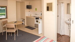 A compact room with a kitchenette, a dining area, and a bathroom. - Kalganyi Holiday Park (Mount Gambier)