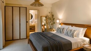 A bedroom with a wooden bed, a bedside table, a hanging lamp, a mirror, and a sliding door. - The Attican Villa & Estate (Saronikos)
