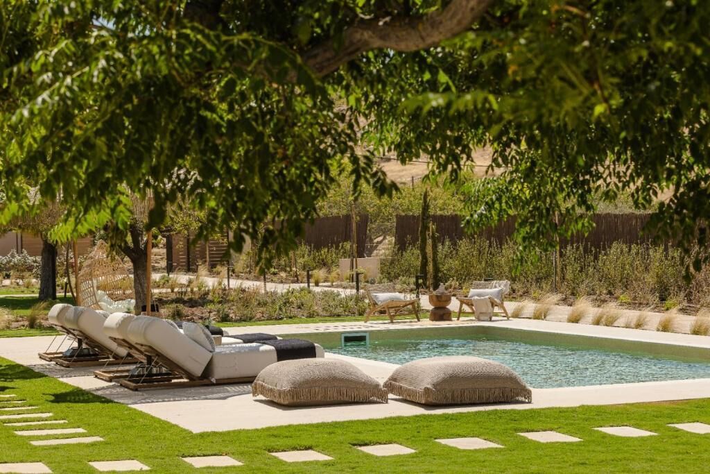 A pool area with lounge chairs and a small pool.