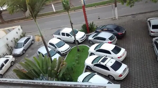 A parking lot with several white cars parked in rows, surrounded by palm trees and a paved walkway. - Tarik Fontes Plaza Hotel (Itabuna)