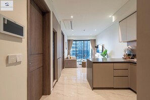 Deluxe-lejlighed - 1 kingsize-seng - ikke-ryger - byudsigt | Opholdsområde | 24-tommers tv med kabelkanaler, bøger, musikbibliotek