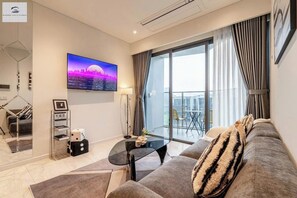 Deluxe Apartment, 2 Bedrooms, Patio | Living area | 24-inch TV with cable channels, books, music library