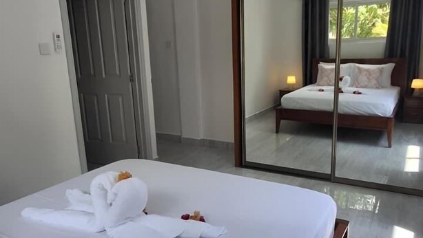 Ein Hotelzimmer mit einem großen Bett, einer Schiebetür zum Balkon und einer Holzbalkendecke.