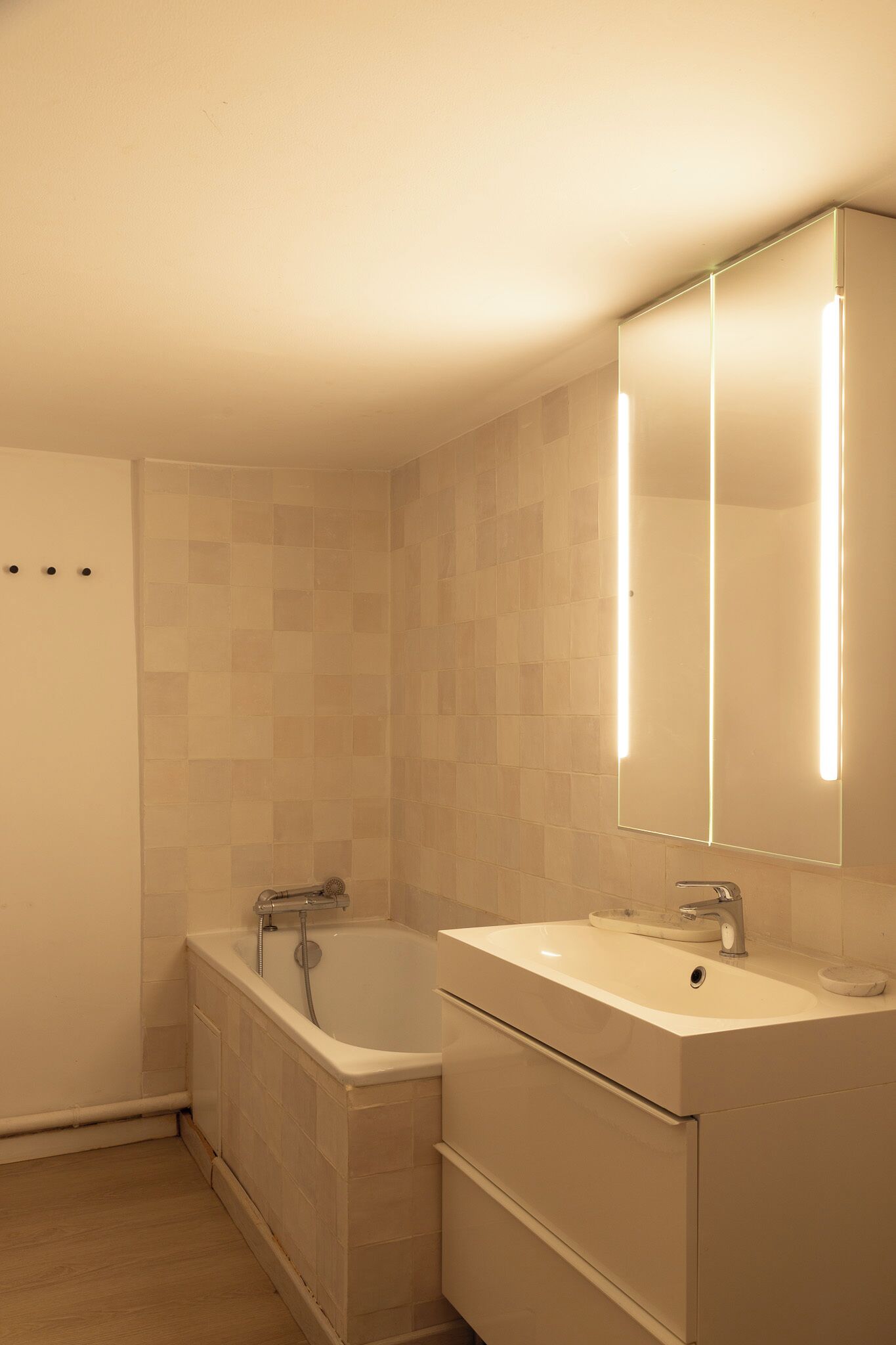 Une salle de bain avec une baignoire, un lavabo et un miroir.