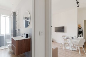 A modern bathroom with a wooden vanity, a large mirror, and a shower area. - GuestHost - Modern Apartment Lambrate Milano (Milan)