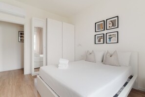Un dormitorio con cama, armario y puerta que da a otra habitación.