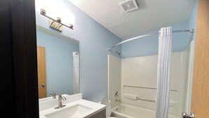 Un baño con lavamanos, inodoro y bañera.