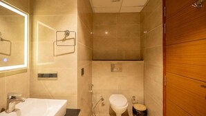 Un baño moderno con un lavamanos grande, un inodoro y una ducha.