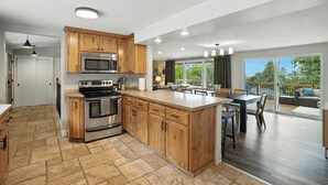 A modern kitchen with wooden cabinets, stainless steel appliances, and a large island. - The South Perry Perch ~ 5BD Family Retreat (Spokane)