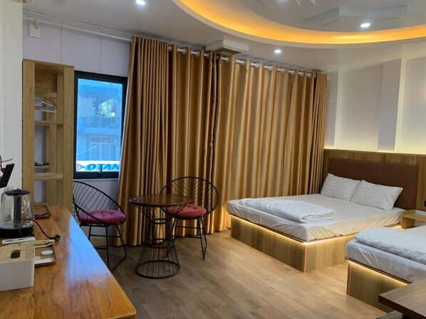 Una habitación de hotel con cama, escritorio, silla y una mesita.