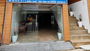 The entrance of Thanh Nam Hotel with a clear signboard, a staircase leading to the entrance, and a visible interior space with a counter and chairs. - Thành Nam Hotel (Dien Bien Phu)