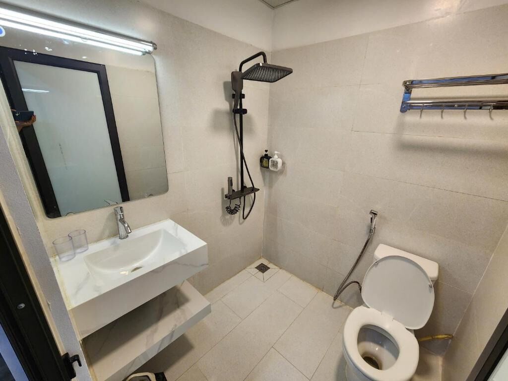 Un bagno piccolo con un lavandino bianco, uno specchio, un soffione e un water.