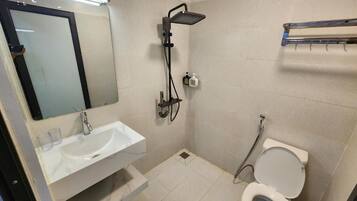 Un bagno piccolo con un lavandino bianco, uno specchio, un soffione e un water.