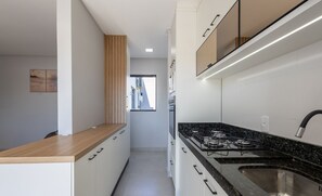 A modern kitchen with white cabinets, a black granite countertop, and a stainless steel sink. - Apart With Barbecue Close to the Beach Smo0202 (Picarras)