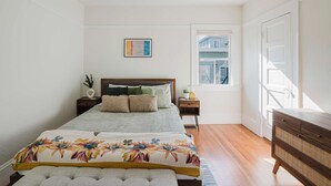 A bedroom with a bed, bedside tables, a dresser, a window, and a door. - Allura Oakland Your Private Sanctuary in the City (Oakland)