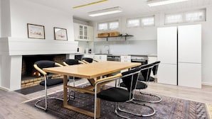 A modern kitchen with white cabinets, a wooden dining table, and black chairs. - The Cozy Oslo Stay (Oslo)