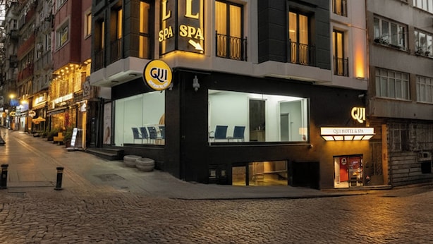 Ett hotell med en modern fasad, flera balkonger och en tydlig skylt som visar att det erbjuder både hotell- och spabehandlingar.