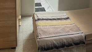 A room with a bed, a wooden wardrobe, and a doorway leading to another room. - House of la Marsa (La Marsa)