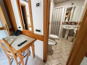 A compact bathroom with a toilet, sink, and shower curtain. - Hotel Pace (San Giovanni Rotondo)