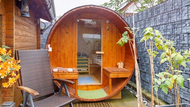 A wooden structure with a curved entrance, a bench, a table, and a small seating area. - Apartment 'Ferienwohnung am Rosenberg' with Shared Garden, Wi-Fi and Air Conditioning (Stockach)