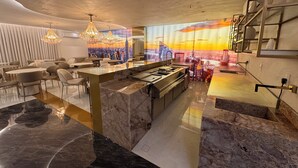 A modern interior with a central island, seating area, and a cityscape mural.