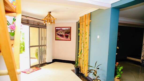 Un vestíbulo de hotel con piso de baldosas, una fotografía enmarcada en la pared y plantas en macetas.