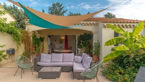Un patio al aire libre con un sofá, sillas y una mesa.
