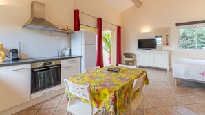 Una cocina con estufa, horno y una mesa de comedor con sillas.