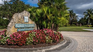 Une enseigne indiquant « Greenlinks Golf Villas at Lely Resort », avec un jardin aménagé en devanture.