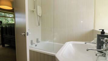 A bathroom with a bathtub, a shower, and a sink.