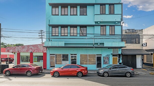 Un edificio de dos pisos con fachada plana y varias ventanas.