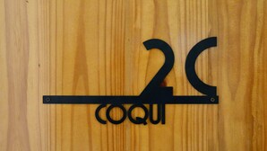 Un letrero de madera con el número 2C y la palabra 'coqui'.