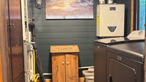 Une petite salle de bain avec un meuble en bois, des toilettes blanches et un radiateur.