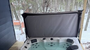 Un bain à remous entouré d’une terrasse en bois.