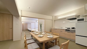Una cocina moderna con comedor, muebles de madera y vista a un dormitorio.