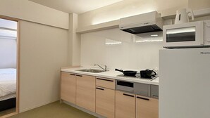 Cocina pequeña con microondas, estufa y lavaplatos.