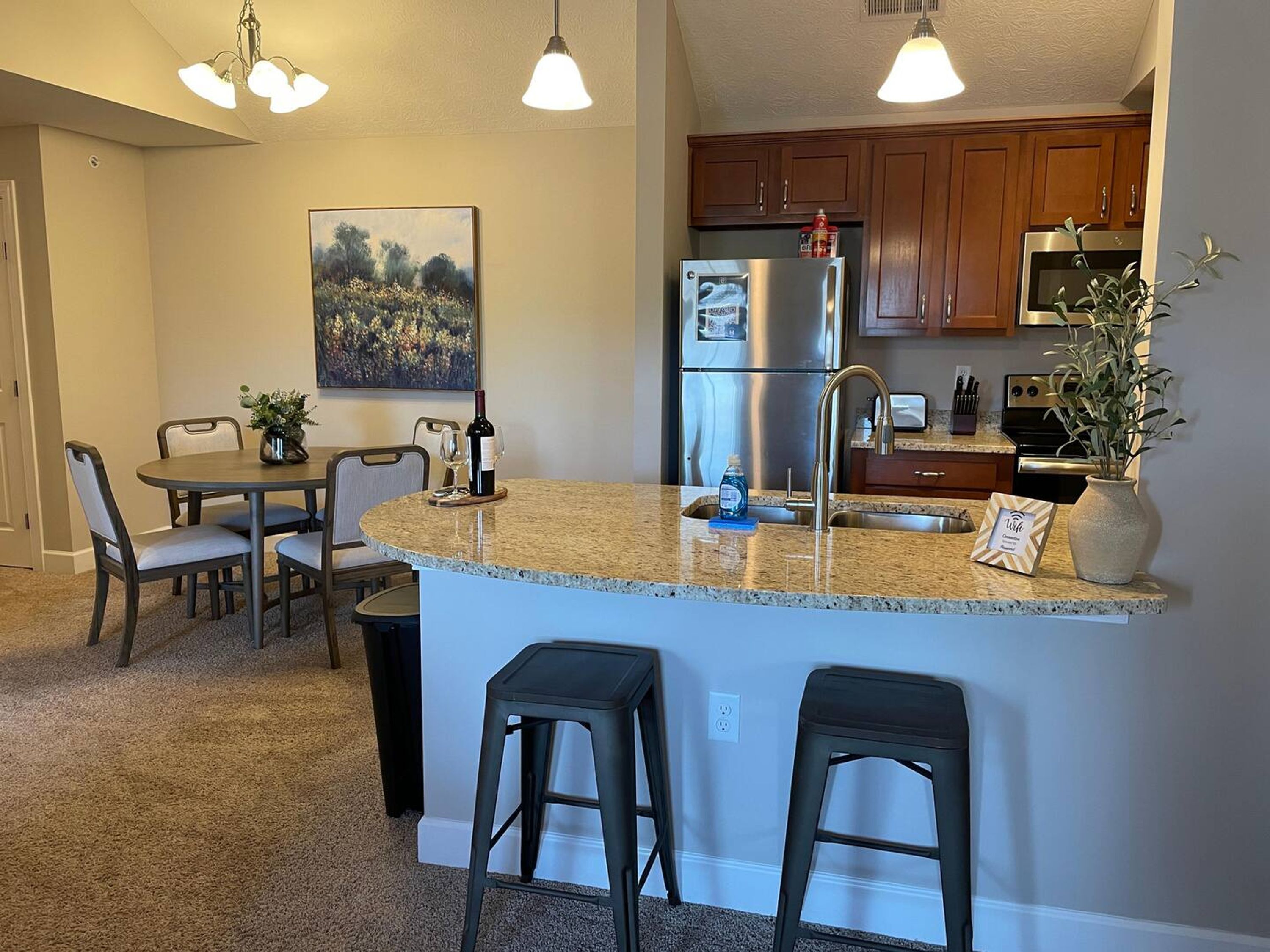 A modern kitchen with granite countertops, stainless steel appliances, and wooden cabinets.