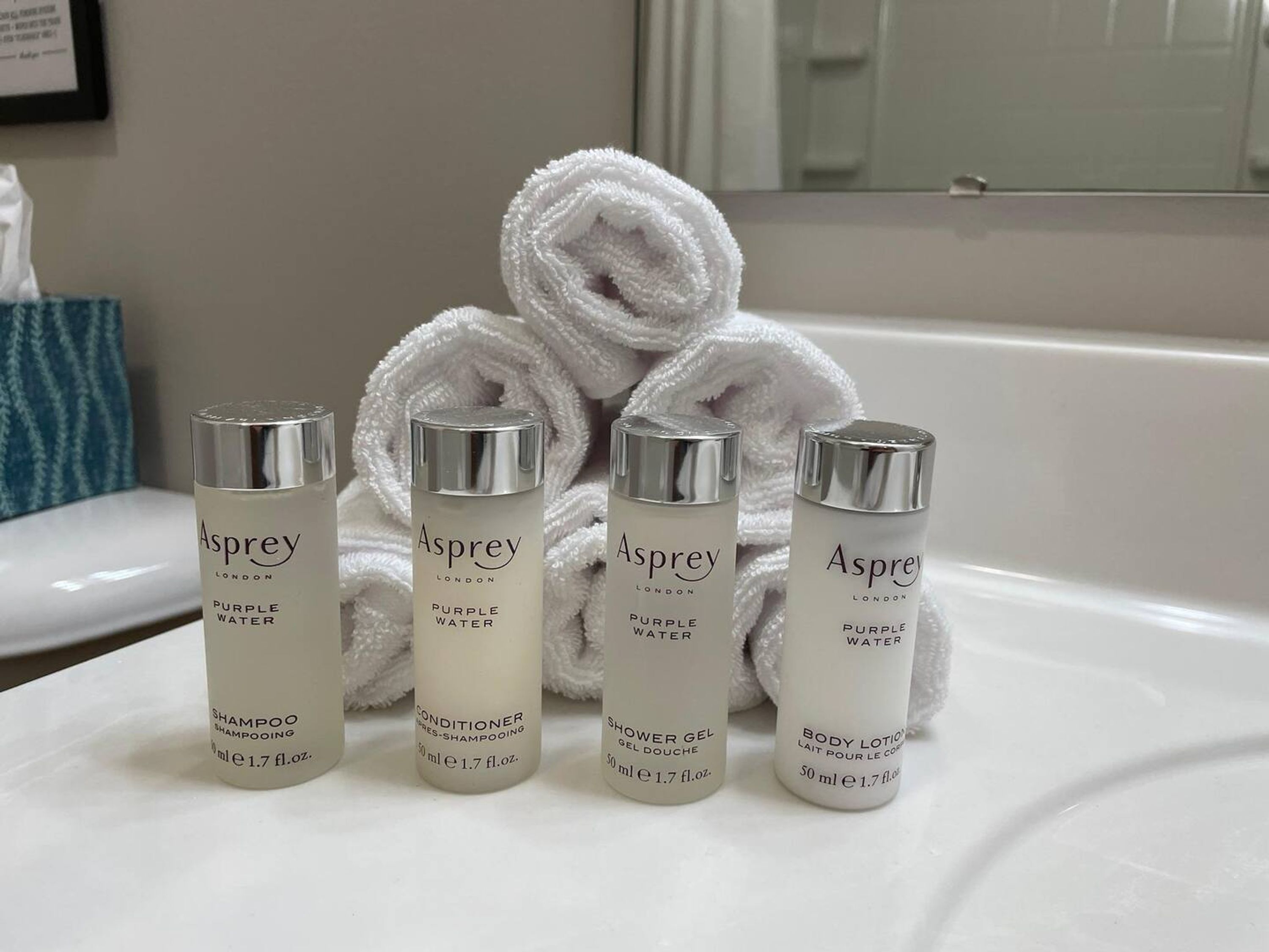 Four bottles of Asprey London products on a white surface.