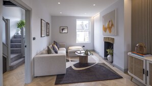 Una sala de estar moderna con un sofá, una mesa de centro y una chimenea.